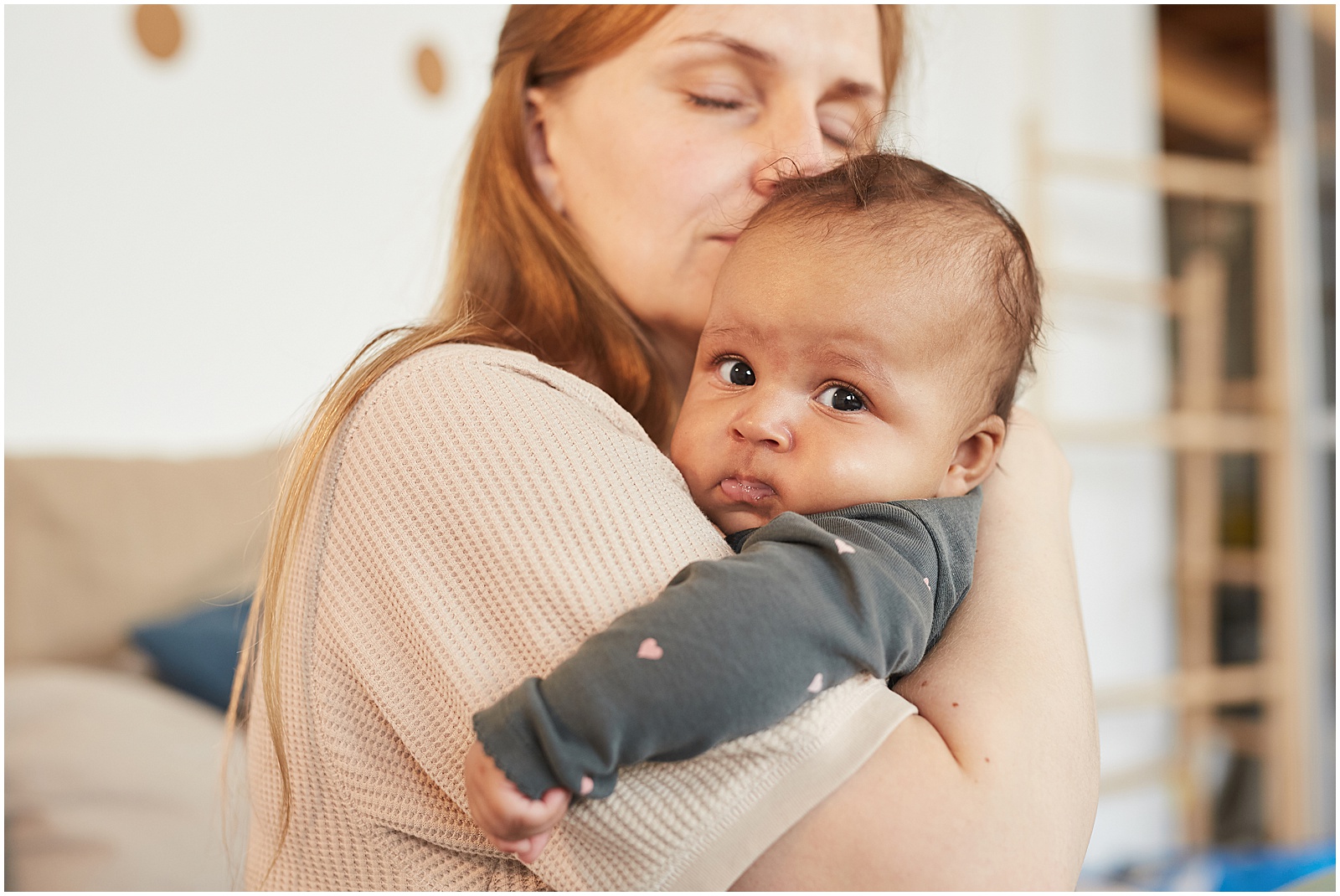 A woman kisses a baby in a photo for a newborn memory book.