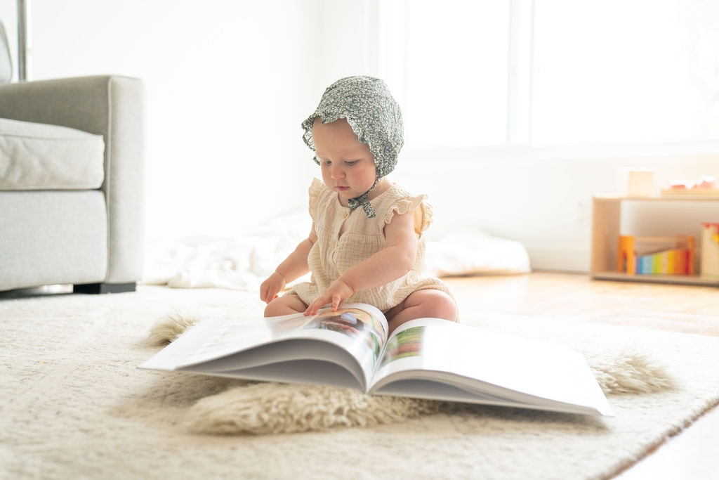 Baby sitting and flipping through modern baby book